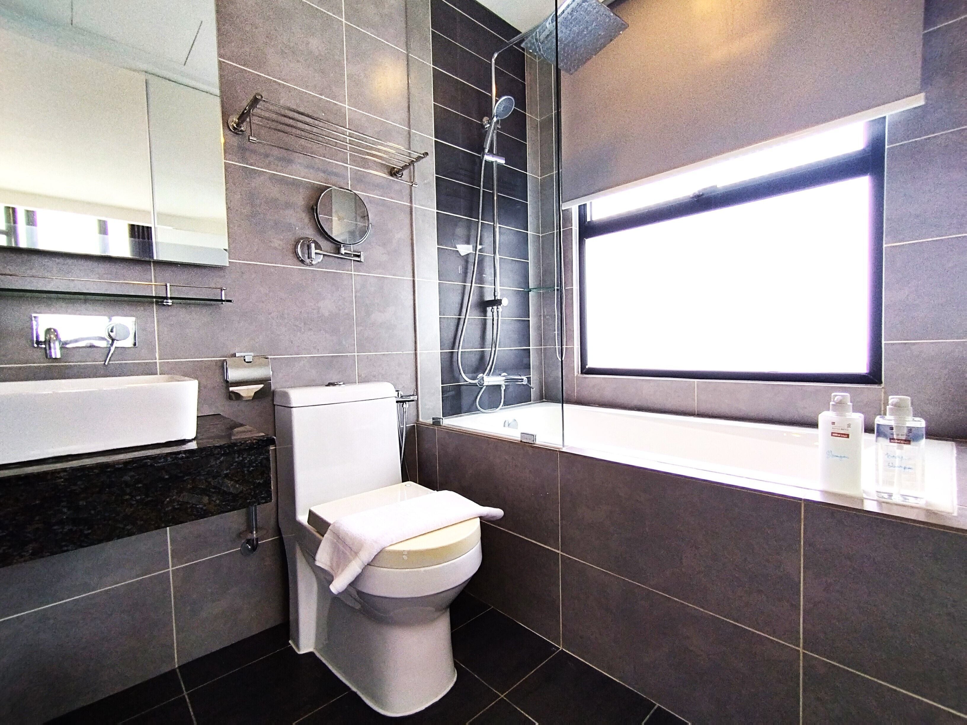 Un baño moderno con inodoro, lavamanos y ducha.