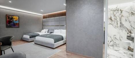 Un dormitorio moderno con una cama grande, una cama más pequeña y una zona de estar con sillones.