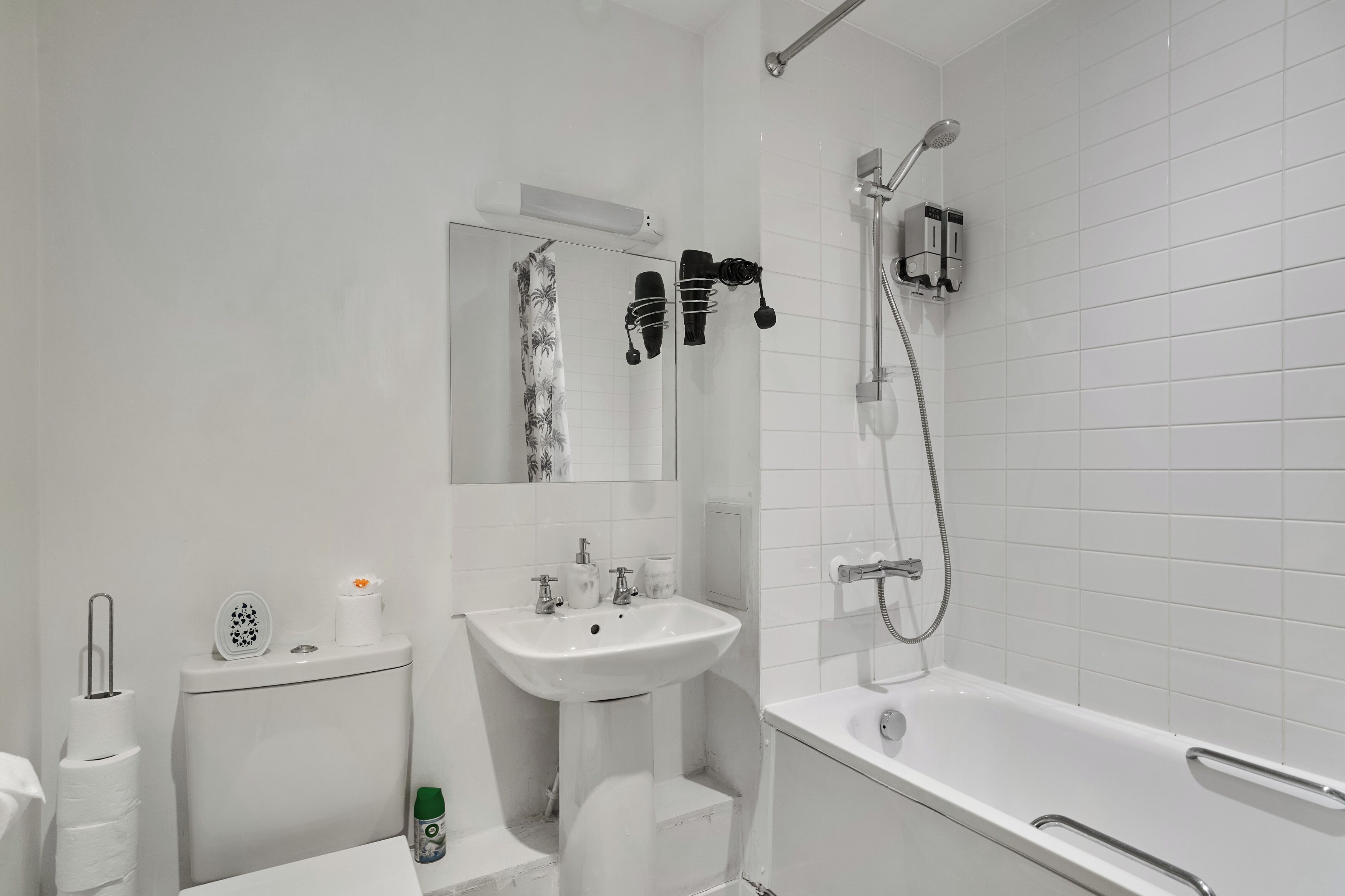 A modern bathroom with a white sink, toilet, and bathtub.