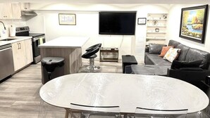 Una cocina moderna con comedor, un televisor de pantalla plana y un sofá.