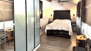 Un dormitorio con cama, escritorio, silla, armario y ventilador de techo.