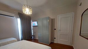 Ett sovrum med en säng, en garderob och en tv på väggen.