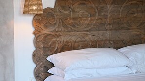A bed with a wooden headboard, white bedding, and a hanging light fixture. - Muza Beach Villa Steps to Most Requested Beach! (Puntarenas Province)