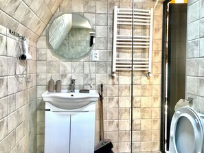 A bathroom with a sink, mirror, towel rack, and toilet. - Hillside kazbegi (Kazbegi)