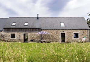A stone building with a sloped roof, two windows, and a door. - Gîtes de Lézinadou - 6 personnes - Plomeur La Torche (plomeur)