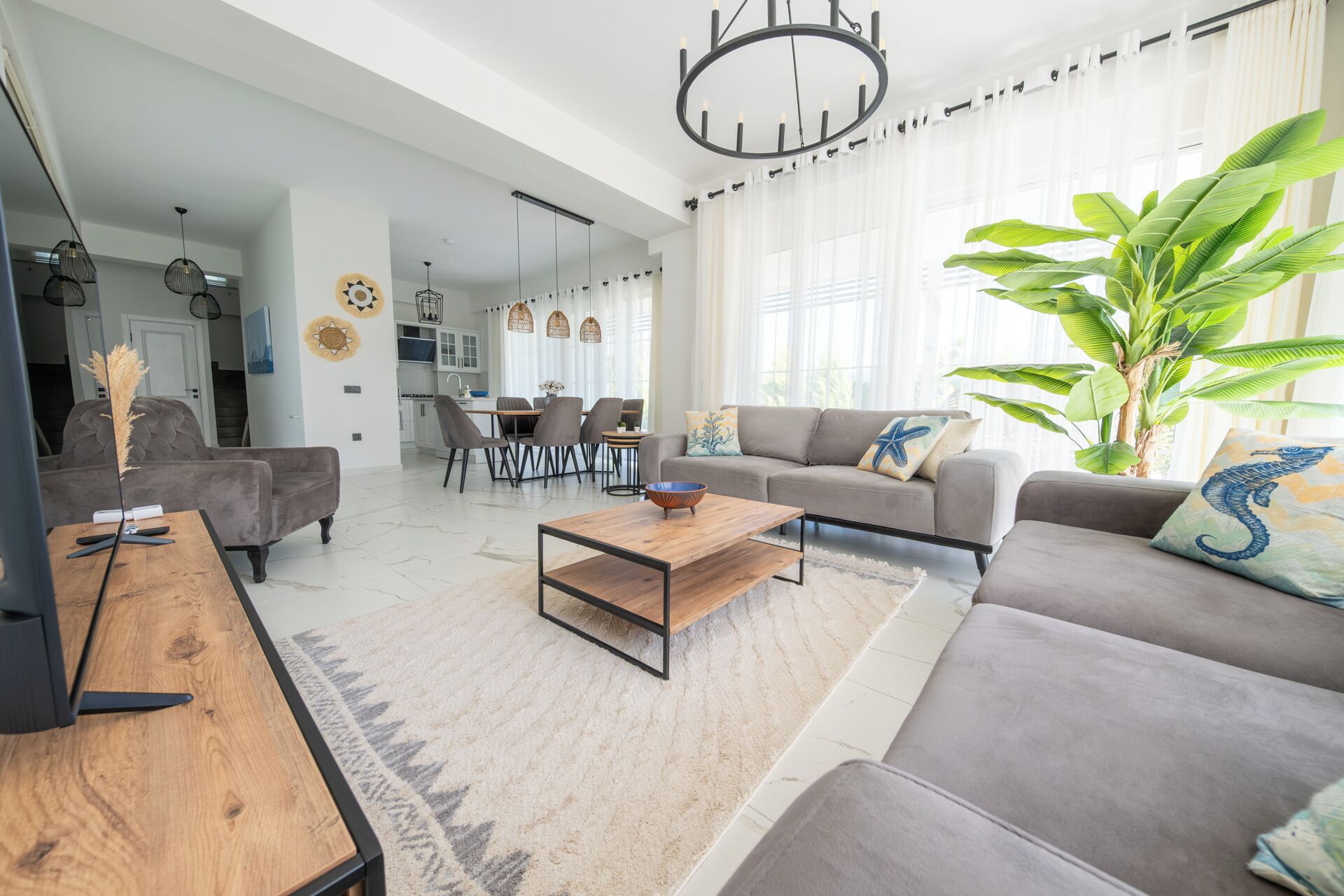 A modern living room with a sofa, coffee table, and dining area.