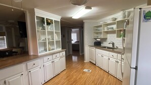 A kitchen with white cabinets, a refrigerator, and a countertop with a toaster. - Golfers getaway with sunny beaches too  (North Fort Myers)