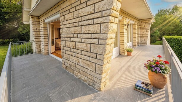 A house with a stone exterior, a covered porch, and a potted plant with flowers. - VILLA EDOUARD - 180m2 in the heart of nature - 20min Disney - 7min Airport (Claye-Souilly)