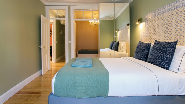 Une chambre à coucher avec un grand lit, un dressing et un lustre.