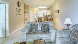 A living room with a grey sofa, patterned cushions, a coffee table, and a lamp. - Golf Getaway w/ Pool Access in Myrtle Beach! (Myrtle Beach)
