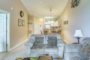 A living room with a grey sofa, patterned cushions, a coffee table, and a lamp.