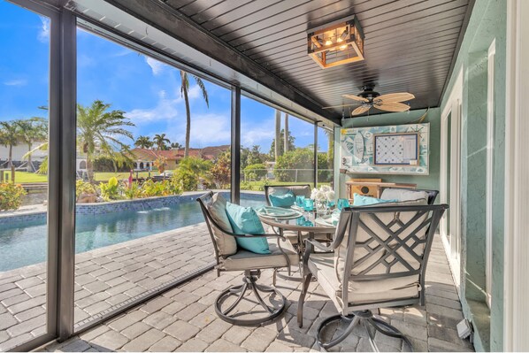 Relax by the pool with a view, surrounded by lush greenery and a patio with a table and chairs.
