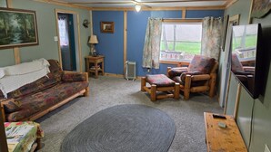 A cozy living room with a sofa, armchair, and a small table.