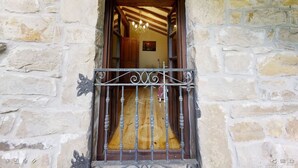 Un edificio in pietra con una porta di legno e un cancello in metallo.