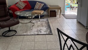 A living room with a sofa, armchair, coffee table, and a ceiling fan. - Walk to Siesta Key Beach. 1 BR condo on ground floor, steps away from the pool (Sarasota)