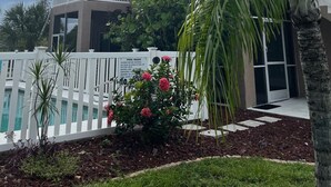 A two-story building with a covered balcony, a pool area with a white fence, and a sign with pool rules. - Walk to Siesta Key Beach. 1 BR condo on ground floor, steps away from the pool (Sarasota)