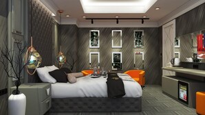 Una habitación de hotel moderna con una cama grande, un escritorio y un minibar.