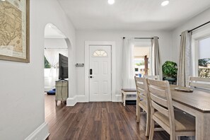 Enjoy meals in the dining area with a wooden table and chairs, and relax in front of the mounted television.
