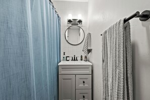 Bathroom features a sink, mirror, and towel rack.