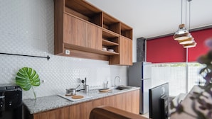 Eine moderne Küche mit Holzschränken, einer Granit Arbeitsplatte und einer roten Akzentwand.