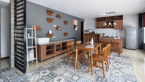 Eine moderne Küche mit Holzschränken, einem Essbereich mit Tisch und Stühlen sowie einem Fliesenboden mit Muster.