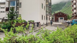 En bygning med flere etager, hvid facade, altaner og et skilt på væggen.