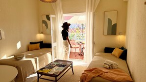 Una habitación acogedora con un sofá, una mesita con revistas y vistas al exterior a través de una ventana.