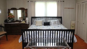 A bedroom with a bed, dresser, chair, and a crib. - Relaxing, quiet country setting. Close to many Mountain activities! (Sugar Grove)