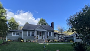 A two-story house with a front porch, a chimney, and a well-maintained lawn. - Relaxing, quiet country setting. Close to many Mountain activities! (Sugar Grove)