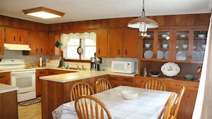 A kitchen with wooden cabinets, a microwave, a stove, and a dining table with chairs. - Relaxing, quiet country setting. Close to many Mountain activities! (Sugar Grove)