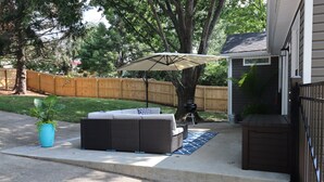 A patio with a sofa, a large umbrella, and a potted plant. - Minutes to Keeneland/Airport/UK & more! (Lexington)
