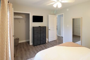 A bedroom with a bed, a dresser, a television, and a closet. - Minutes to Keeneland/Airport/UK & more! (Lexington)