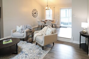 A living room with a sofa, armchairs, a coffee table, and a dining area with chairs and a table. - Minutes to Keeneland/Airport/UK & more! (Lexington)