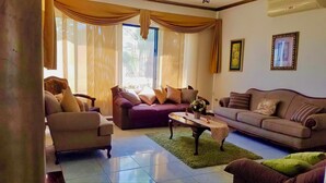 A living room with a sofa, armchair, and a coffee table. - Villa Mar Azul (Manta)