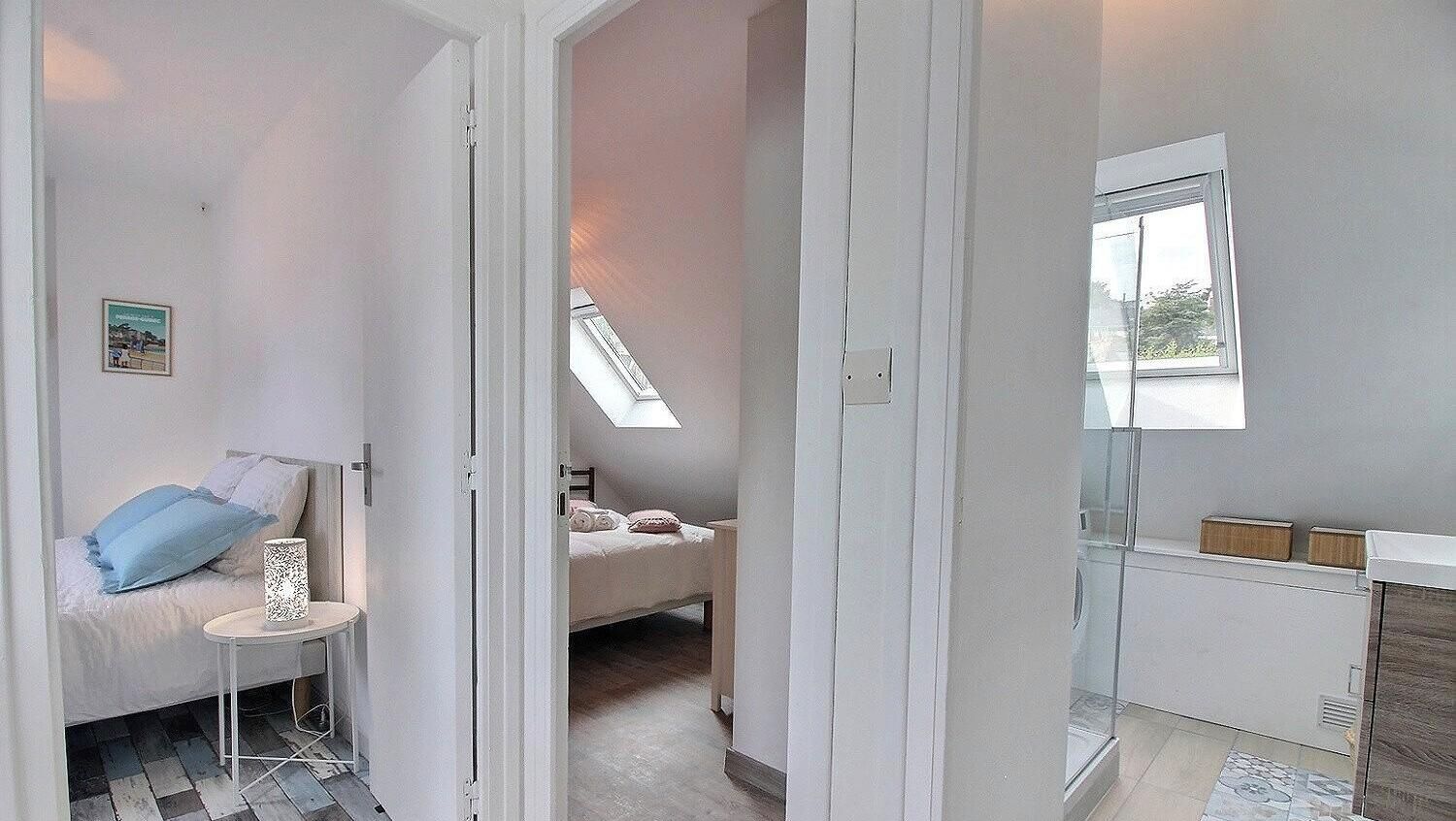 A bedroom with a bed, a bedside table, and a window.