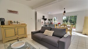 A modern living room with a grey sofa, a glass coffee table, and a yellow cabinet.