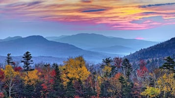 Un paysage montagneux aux couleurs automnales, avec un ciel éclatant.