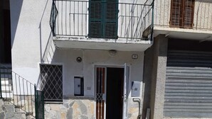 Un bâtiment doté d’une façade en pierre, d’un portail en métal et d’une porte en métal.