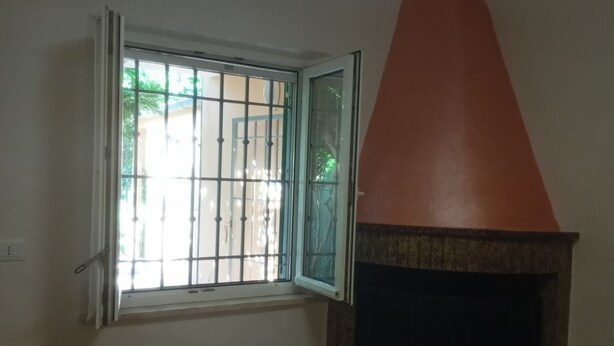A room with a fireplace, a window with bars, and a chair. - SE019 - Senigallia, delightful townhouse with portico (Senigallia)