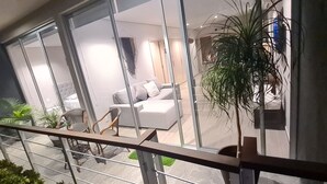 Ein modernes Wohnzimmer mit einer Couch, Sesseln und einem großen Fenster.