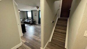 A hallway leading to a living room with a sofa and a dining table. - A W🌊VE From It All! Secure boat storage, huge yard, lots of outdoor games! (Page)