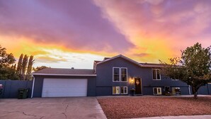 A two-story house with a garage, a driveway, and a tree in the front yard. - A W🌊VE From It All! Secure boat storage, huge yard, lots of outdoor games! (Page)