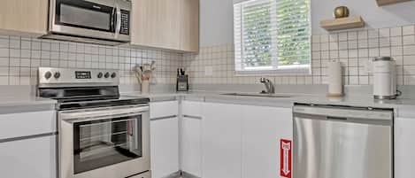 Enjoy cooking in this well-lit kitchen with a microwave, oven, and dishwasher.