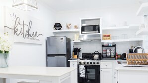 A modern kitchen with white cabinetry, a stainless steel refrigerator, a microwave, and a gas stove. - Oasis on Poitier in Nassau Bahamas - your private retreat. (Nassau)