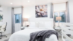 A modern bedroom with a large bed, a ceiling fan, and a window with curtains. - Oasis on Poitier in Nassau Bahamas - your private retreat. (Nassau)