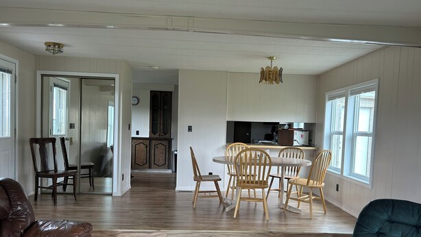 A spacious living area with a dining table and chairs, a leather sofa, and a blue armchair. - Cozy Quiet Home on Sage Creek (Dell)