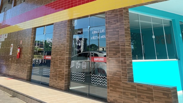 A building with multiple floors, air conditioning units, and a colorful tiled facade. - Suite rooms in Pousada Jesus me Deu in Iguatu/Ce, 200m from the Airport. (Bugi Iguatu)