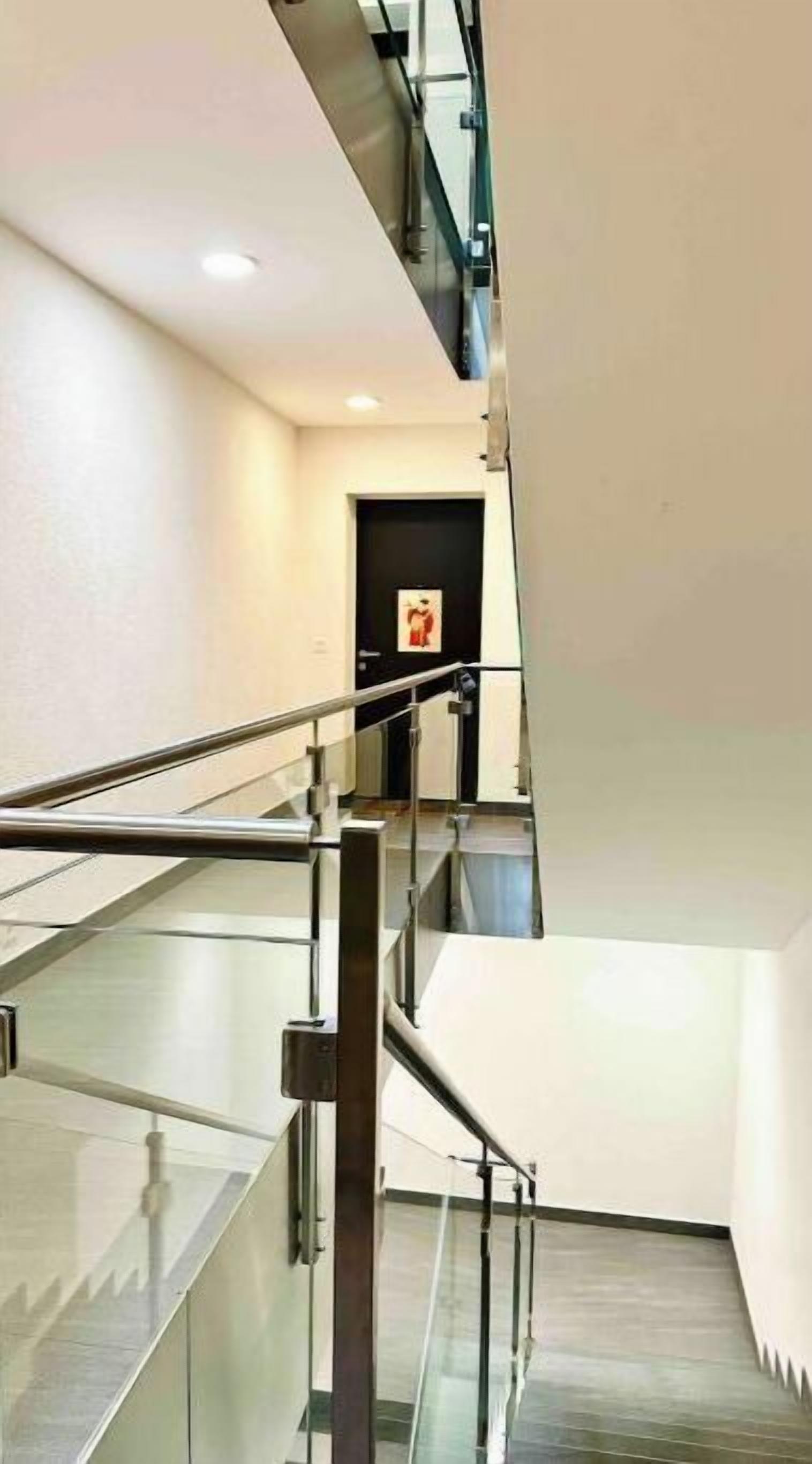 A modern interior with a glass staircase leading to a lower level.