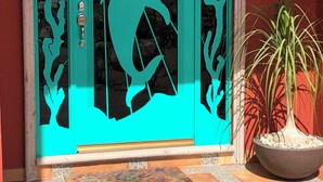 A turquoise door with a dolphin silhouette, a potted plant, and a welcome mat.