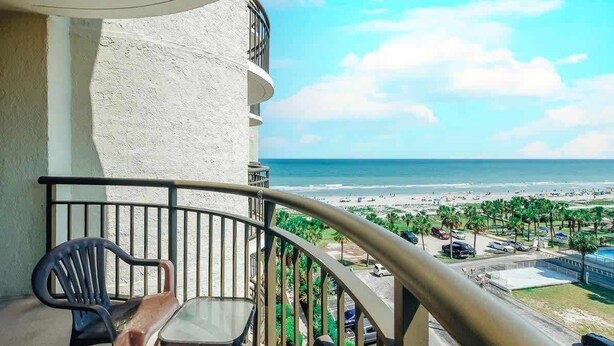 Un balcon avec vue sur la plage et l’océan.